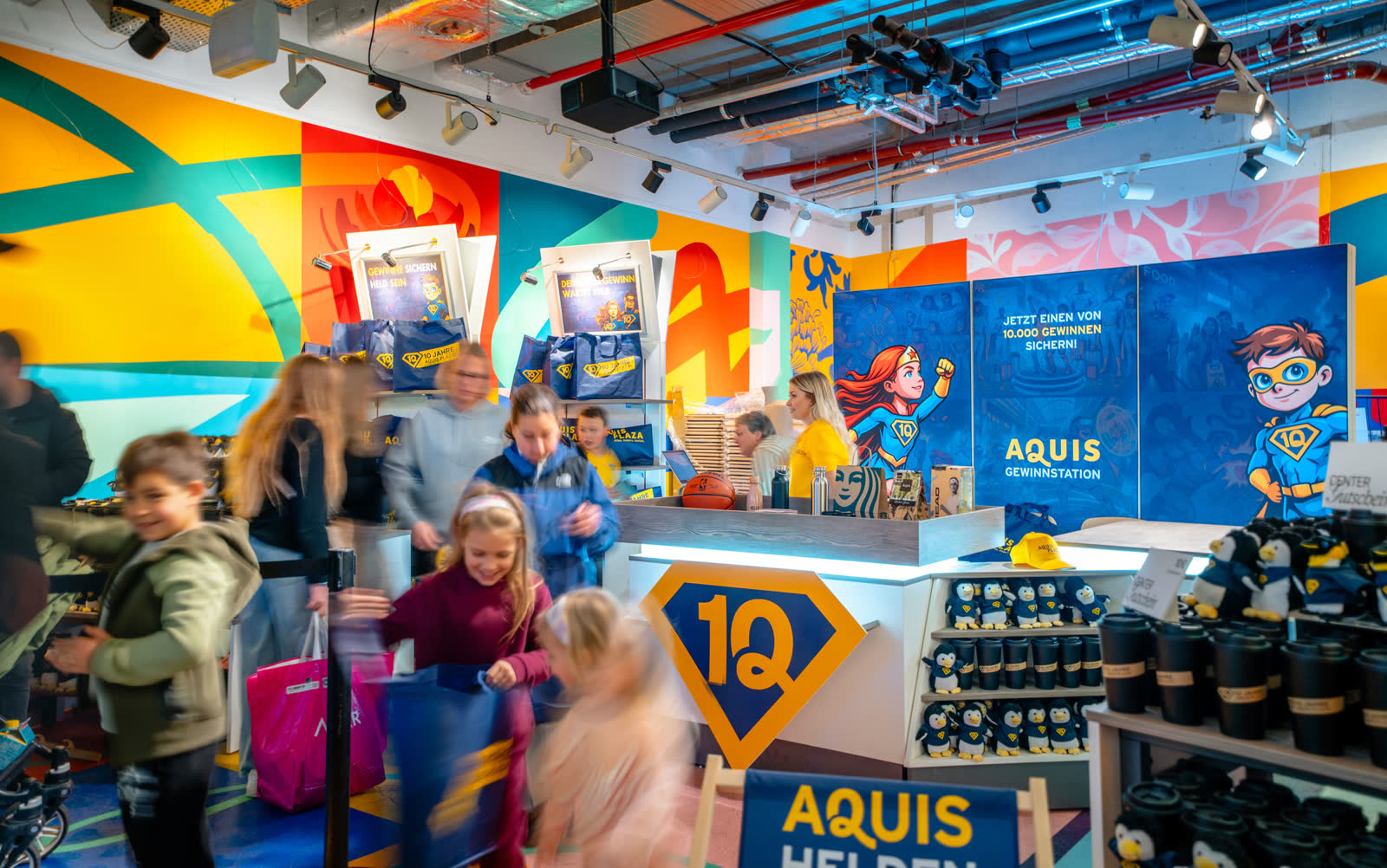 Gestaltete AQUIS-PLAZA-Aktionsfläche mit Markengrafik, Theke und Produktpräsentation