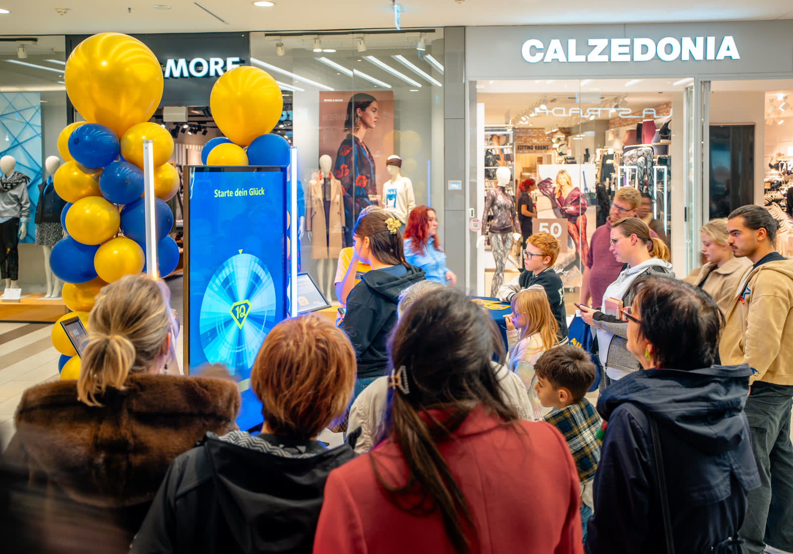 Besucher verfolgen den Dreh am digitalen Glücksrad.