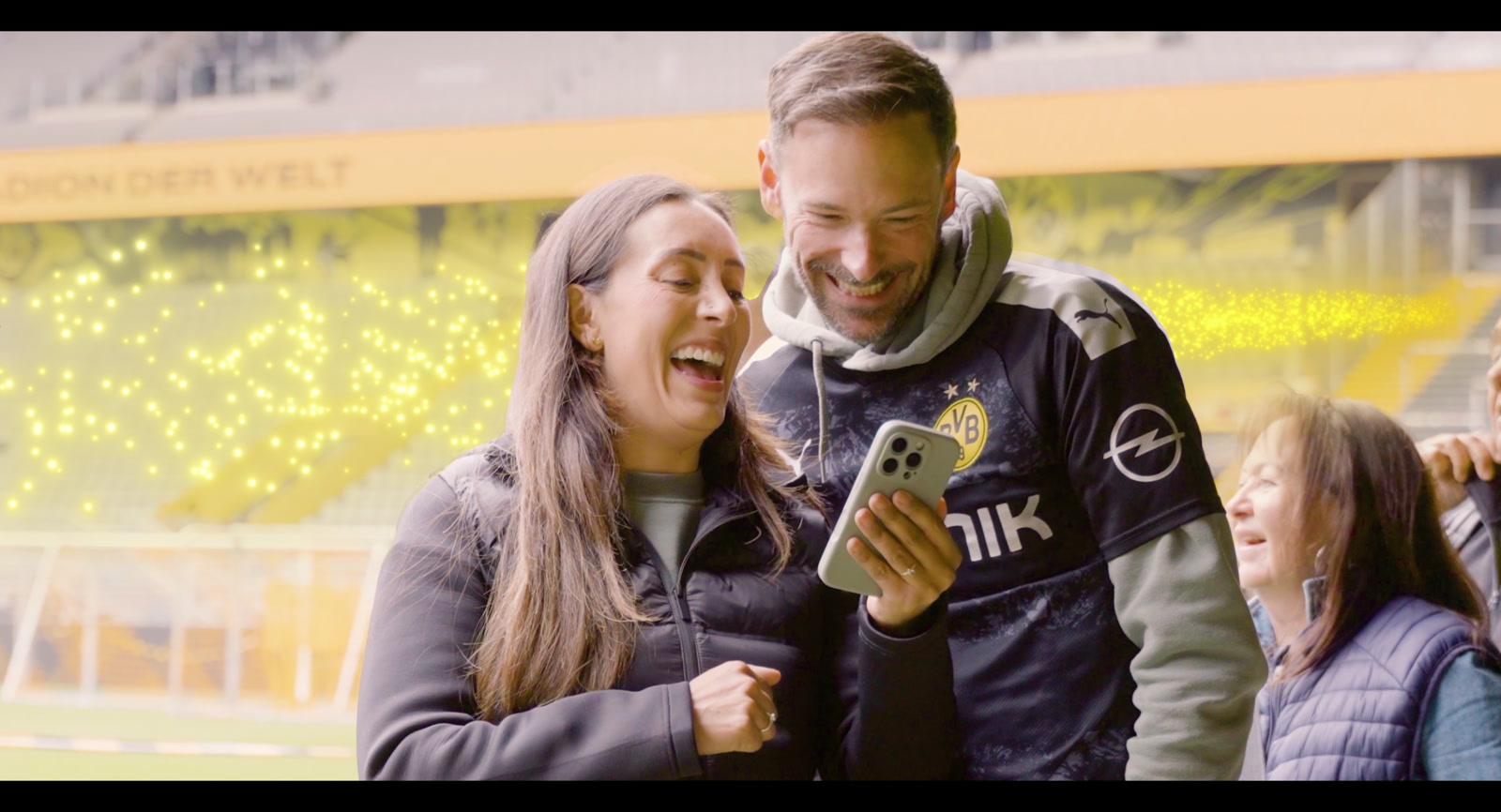Eine Familie entdeckt ihren fertigen Fanclip gemeinsam auf dem Smartphone.